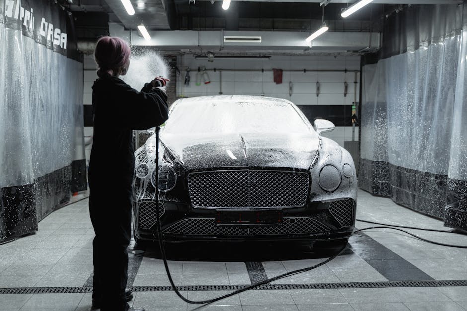 A black Bentley being washed with soap at an indoo