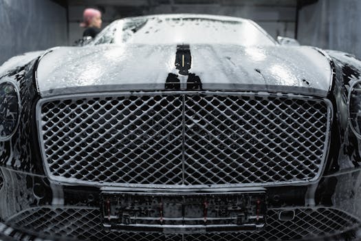 A close up of a luxurious black car being cleaned