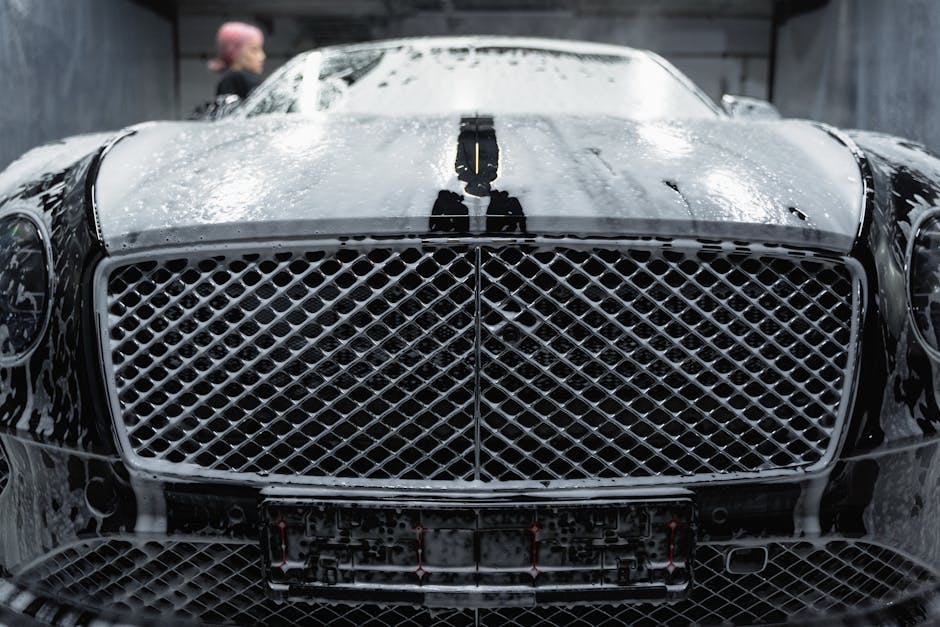 A close up of a luxurious black car being cleaned