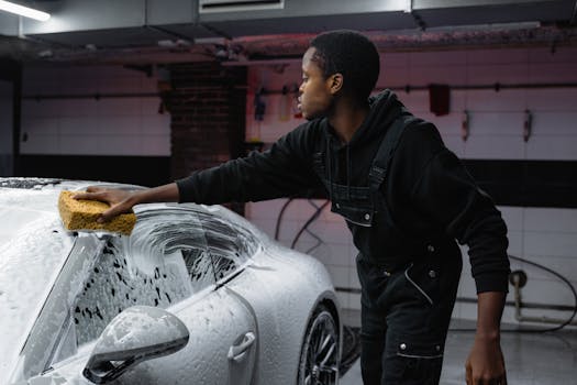 A person washing a car with a sponge deep cleaning