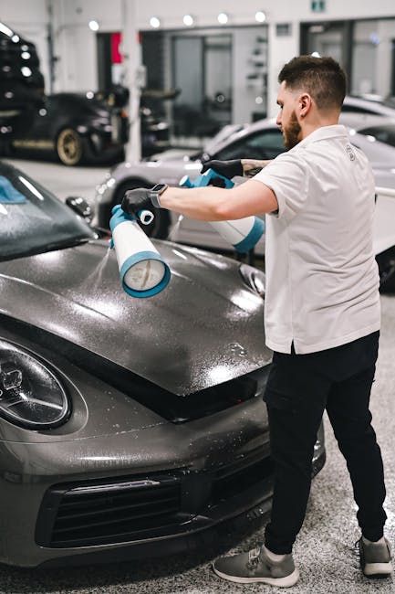 Man polishing luxury sports car with spray in a pr
