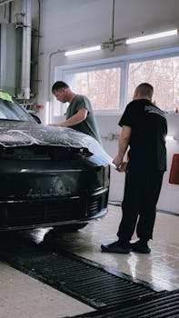 Two professionals applying protective film to a bl