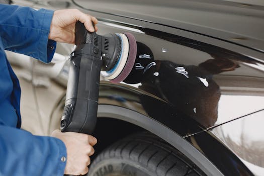 Hands using a polishing machine on a cars surface