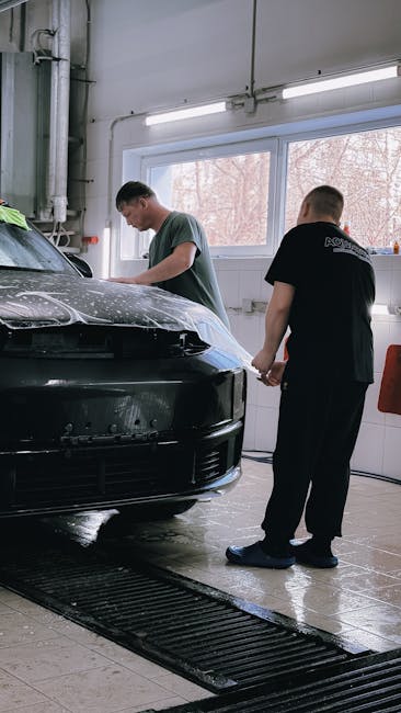 Two professionals applying protective film to a bl