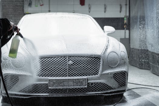A luxury car is covered in foam during a detailed