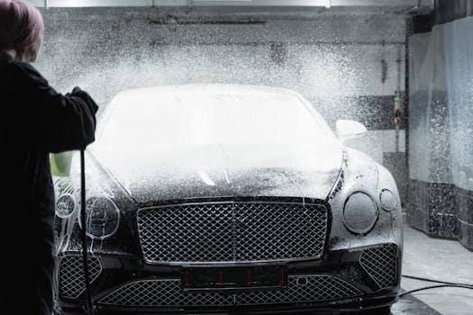 Black luxury car receiving a foamy wash in an indo