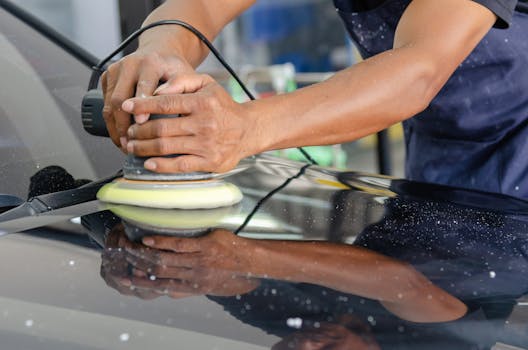 Detailed view of a workers hands polishing a cars
