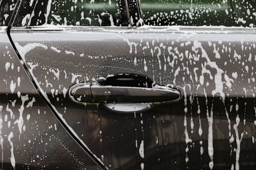 Detailed close up of soap suds on a black car door