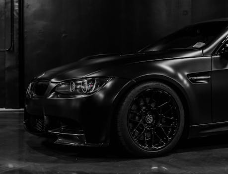 A stylish black sports car parked in a dimly lit s