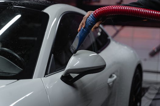 A white sports car is meticulously vacuumed indoor